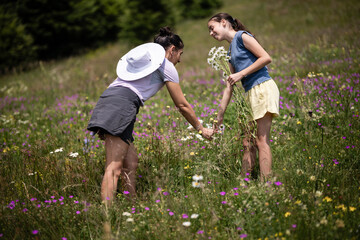 Mother and daughter picking wildflowers in a meadow