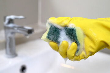  housekeeper is cleaning the faucet in the bathroom.