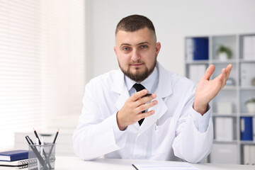 Portrait of doctor in uniform at table indoors