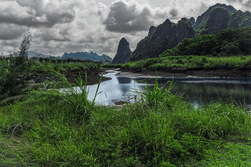 River mountain grassland landscape in cloudy overcast day.