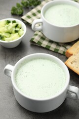 Tasty cucumber soup served on grey table, closeup