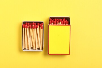 Matches and boxes on yellow background, flat lay. Mockup for design
