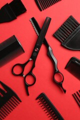 Different hairdresser's tools on red background, flat lay