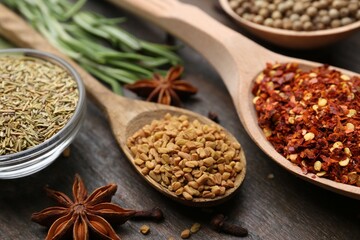 Different aromatic spices on wooden table, closeup