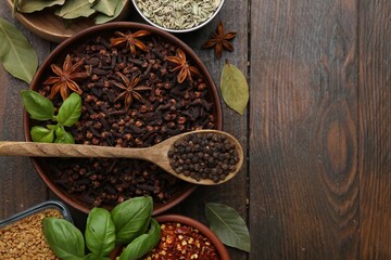 Different aromatic spices on wooden table, flat lay. Space for text