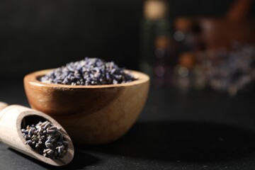 Dry lavender flowers on black table, closeup and space for text. Making essential oil