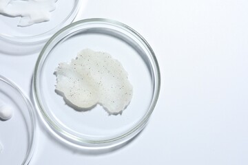 Different cosmetic products in Petri dishes on white background, flat lay. Space for text