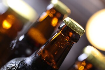 Bottle of tasty beer on blurred grey background, macro view