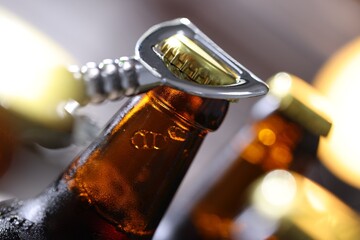 Opening bottle of beer on blurred grey background, closeup