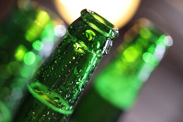 Bottle of tasty beer on blurred grey background, macro view
