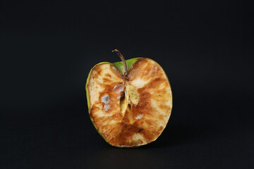 Half of spoiled apple on black background