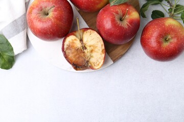 Spoiled apple and good ones on white table, flat lay. Space for text