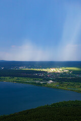 Obraz premium Sunlight shining on village during rainfall