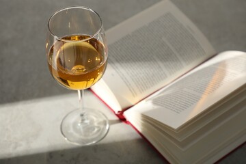 Glass of wine and book on grey table