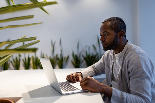 African American man participating in video call on laptop at office desk