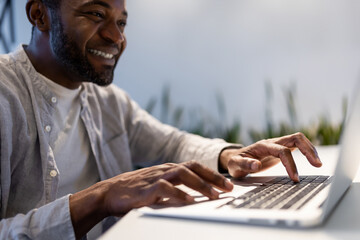 Smiling businessman reacting emotionally while using computer at work desk in professional workspace