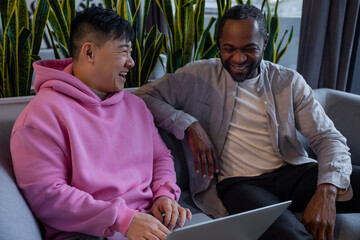 Smiling diverse team members working together on computer in casual office environment