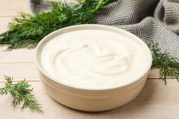 Tasty sour cream and dill on white wooden table, closeup