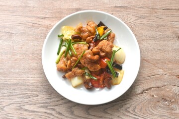 fried slice crispy chicken meat with cashew nut and bell pepper couple onion on plate 
