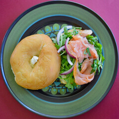 A salmon bagel with rocket and Spanish onion. 