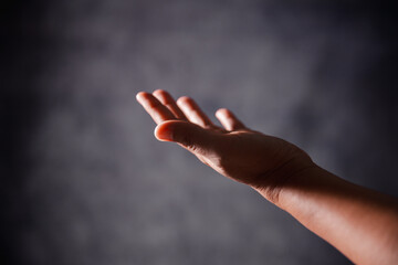 Christian woman lifts her hand in worship to pray, hope, faith, and deep belief in God defines core...