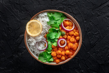 Chana masala, chickpea curry, traditional Indian dish, overhead flat lay shot on a black background