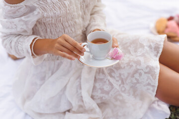 Stylish Woman Enjoying Tea Outdoors With Pink Flower On Saucer