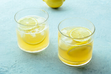 Glasses of lemonade, a mocktail with lemon juice, on a blue background, summer cold drink, with a fresh fruit