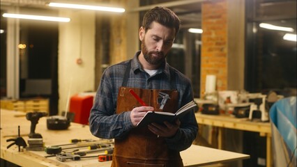 Pensive Caucasian worker male wood master workman man guy carpenter writing notebook puzzled...