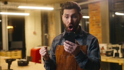 Amazed Caucasian wood master repairman man guy male scroll mobile phone surprise online shocked...