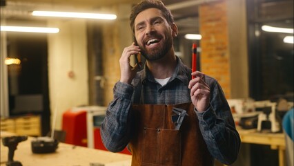 Cheerful glad Caucasian guy builder wood master craftsman man talking mobile phone conversation...