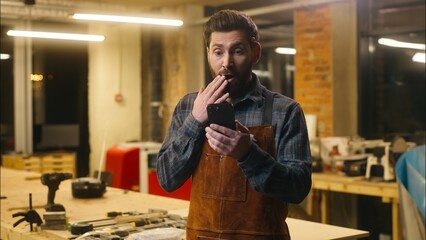 Amazed Caucasian wood master repairman man guy male scroll mobile phone surprise online shocked...
