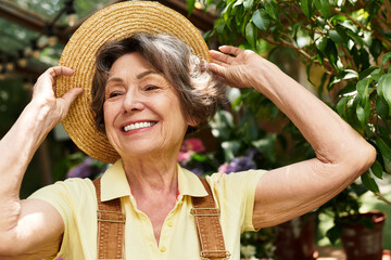 Joyful moments of a senior woman tending to her flourishing garden on a sunny afternoon