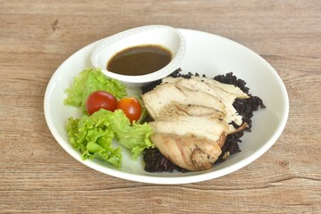 grilled slice chicken black pepper on riceberry with tomato and lettuce on plate dipping Thai spicy...