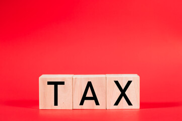 Tax text written on wooden block On a red background