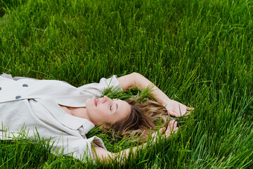 Carefree woman relaxing in a flowering meadow enjoying nature