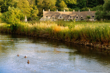Sunset over Arlington Row with ducks swimming in the river in Cotswolds, England