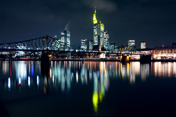 Skyline of the central business district of Frankfurt am Main illuminated at night with the Elserner Steg footbridge