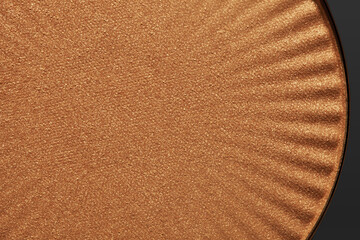 Cosmetic make up beauty product. Dry simmering pressed bronzer deep brown colored textured background corex.