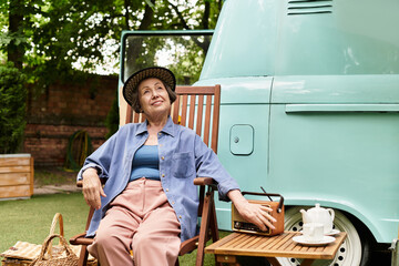 Senior woman enjoying tranquility in a garden oasis with vintage touches