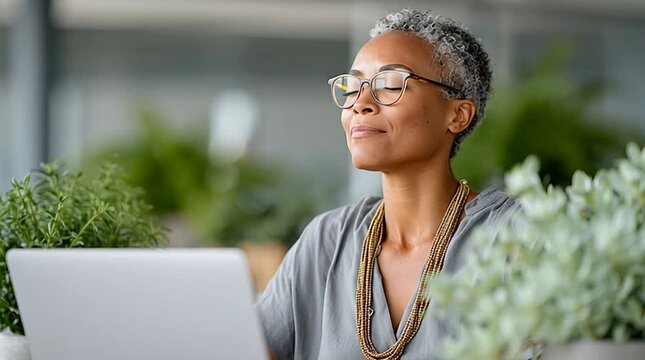 Mature manager taking a break from work to practice mindfulness with deep breathing exercises