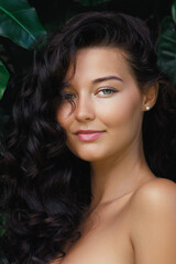 Close-Up of Smiling Woman with Curly Hair and Glowing Skin in Nature