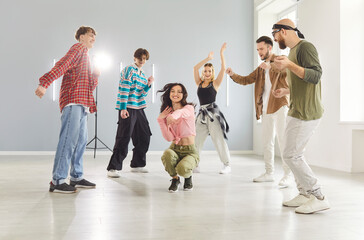 Team of people dancing together to music in dance studio, focusing on choreography and fun,...