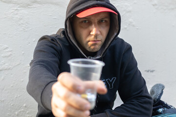 Sad homeless man begs for money at the street