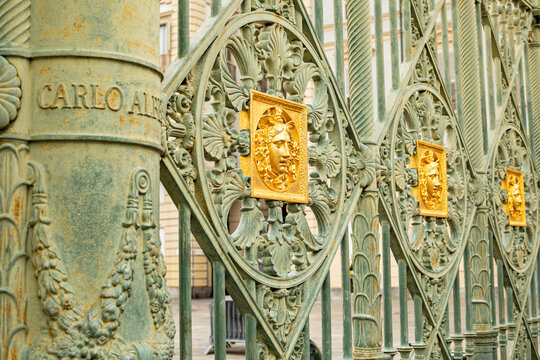 Gates of the Royal Palace 1840 in Turin ,Piedmont, Italy . Wall detail at the Royal Palace of Turin,Italy. Golden mask on the wall of the royal palace
