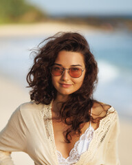 Smiling Woman in Sunglasses and Lace Top Posing on the Beach