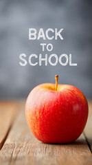 A classic back to school scene with a fresh red apple on a rustic wooden desk. A nostalgic concept with chalk text on a blurred chalkboard background, perfect for education and teachers.