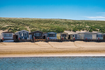 Beach huts on the beach in Egmond aan Zee on the North Sea under a cloudless blue sky