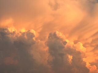 Textured dramatic cumulus orange heap of clouds on sky at sunset. Natural background