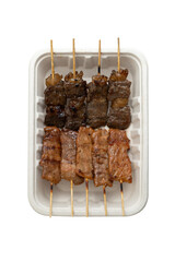 Grilled meat on skewers in paper plate isolated on white